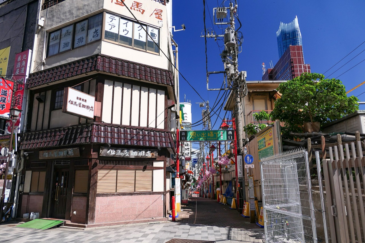 A narrow Shinjuku alley of small izakaya under red lanterns at night